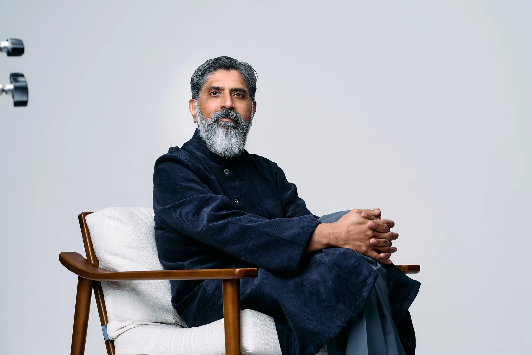 Dr. Yasin Choudry, seated in a chair, contemplative in cinematic light.